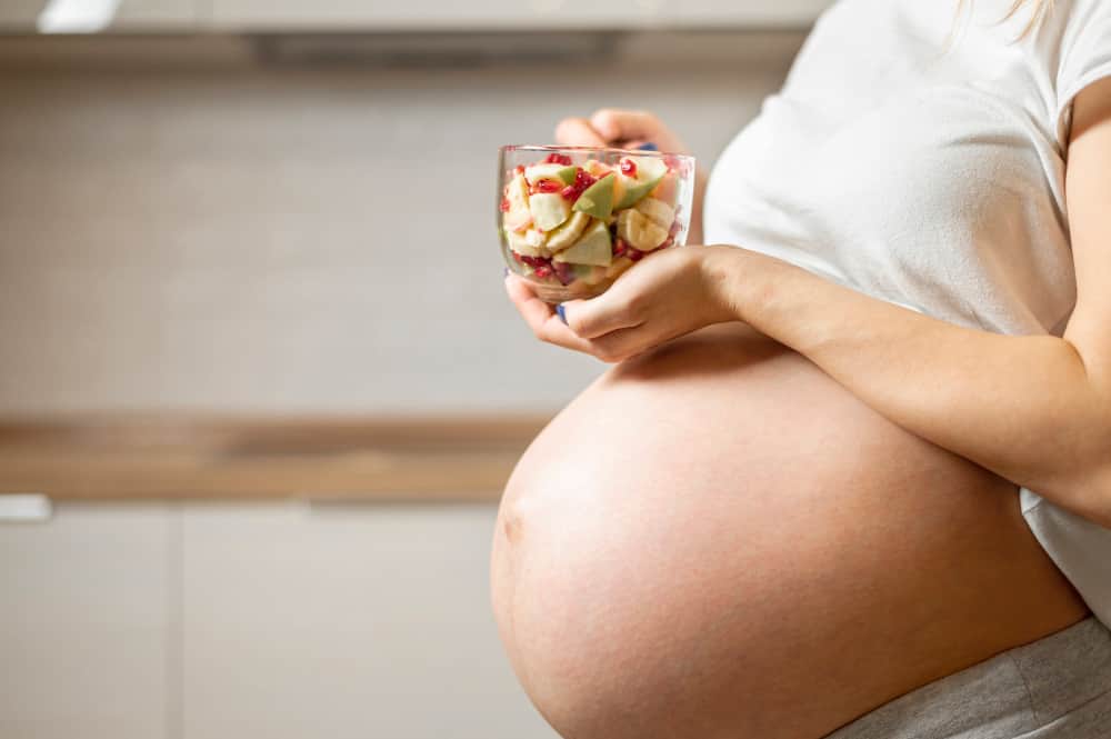 Colorful plate of fruits, vegetables, and grains symbolizing balanced pregnancy nutrition