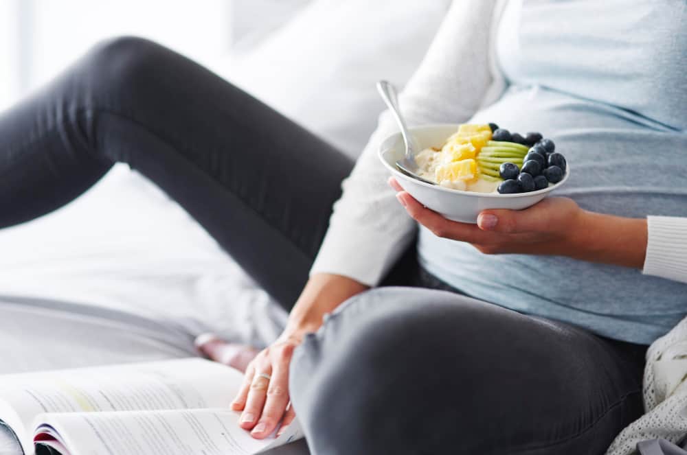 Healthy pregnancy snacks including fruit, yogurt, nuts, and whole grains arranged neatly