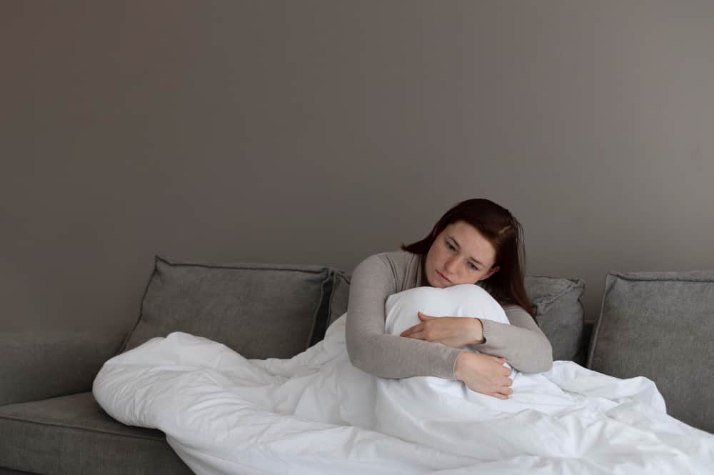 Pregnant woman awake at night looking at clock