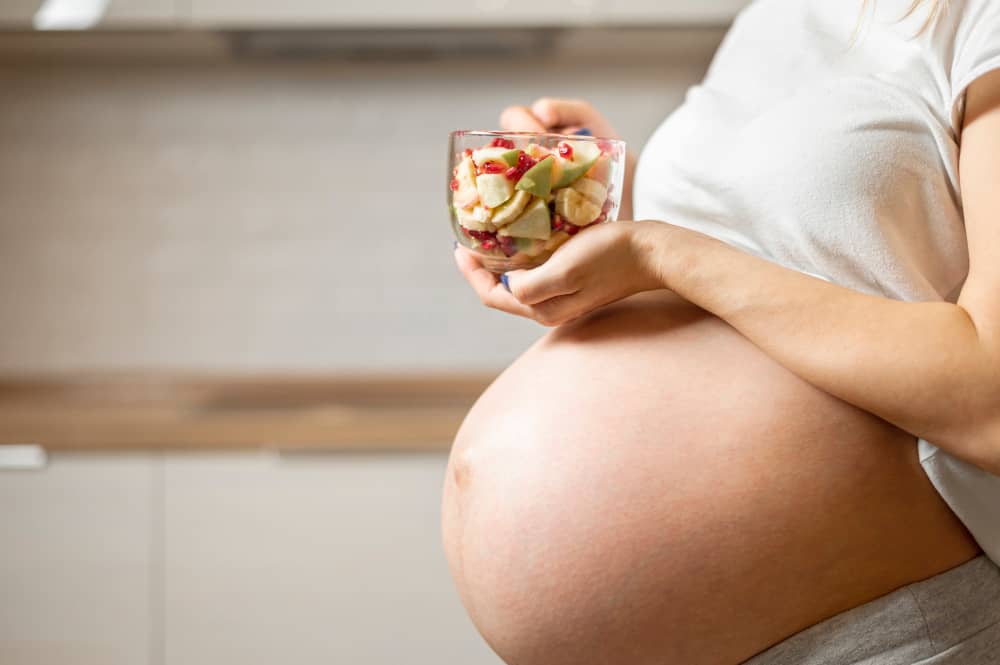 Colorful plate of fruits, vegetables, and grains symbolizing balanced pregnancy nutrition