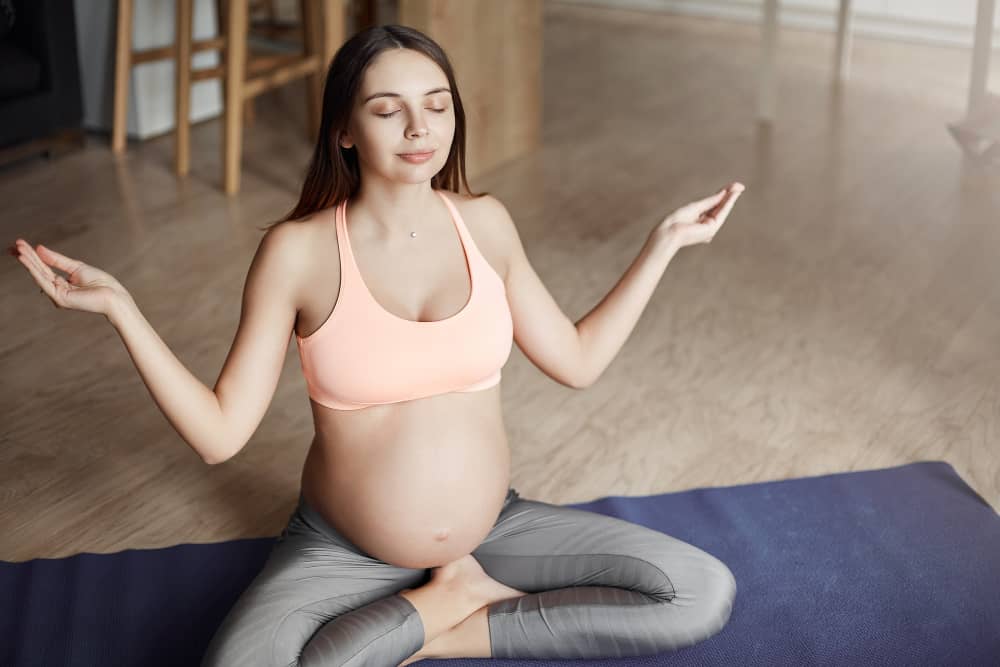Pregnant woman sitting and taking deep breaths while resting