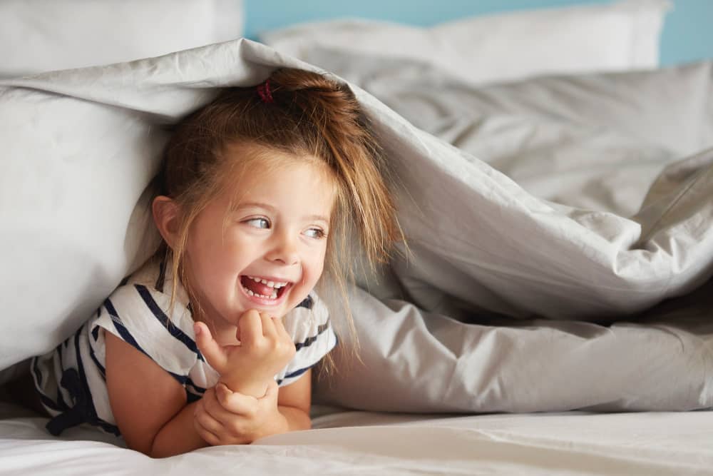 Parent reading a bedtime story to a toddler in a calm, softly lit bedroom