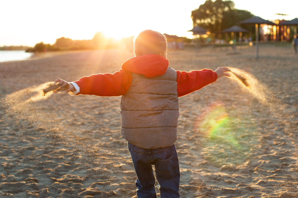 Soft pastel sunrise over gentle hills with subtle baby-themed details